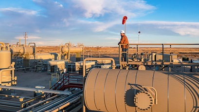 Worker on top of tank at Rockies Business Unit Field Site